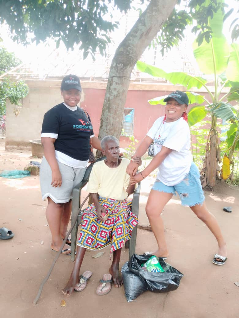 Volunteers spend time with an elderly woman during a household visit.